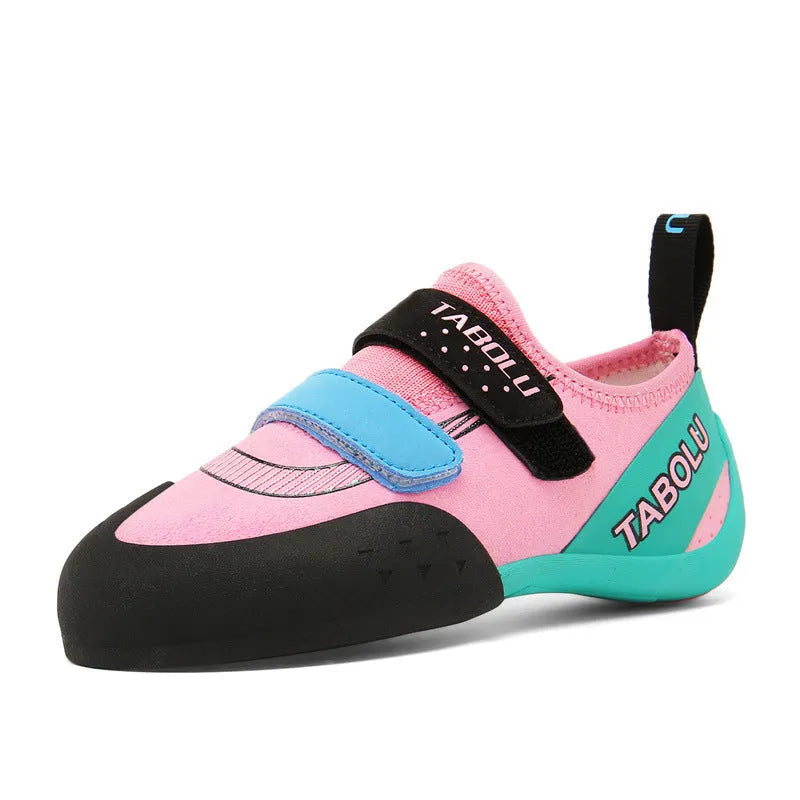 A pair of beginner rock climbing shoes with a velcro strap, shown in a black and red colour combination.