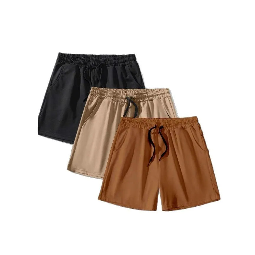 Three men's drawstring shorts in black, khaki and light brown laid flat, showing elastic waistband and loose leg design.