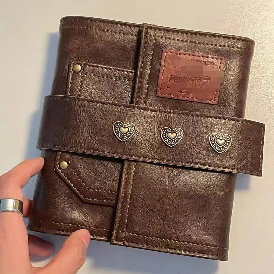 Brown A7 notebook with retro leather buckle closure showing loose-leaf binding