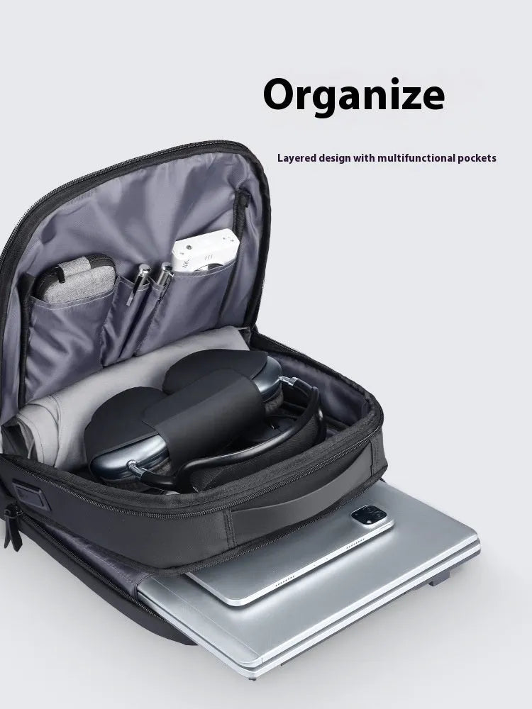 Graphite grey Oxford cloth business backpack featuring an external USB charging port on the shoulder strap.