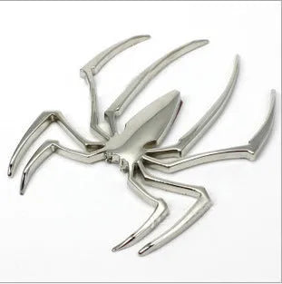 Three-dimensional metal spider bumper sticker in silver finish, measuring 7cm by 5cm.