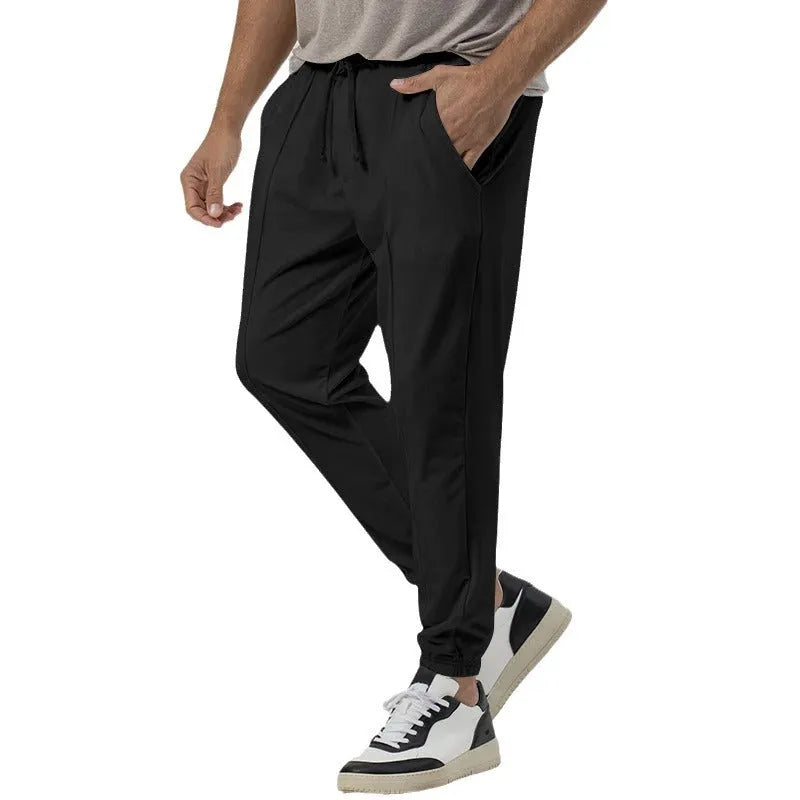 Men's casual track sweatpants in cotton blend fabric showing loose tapered straight-leg design in Army Green colour