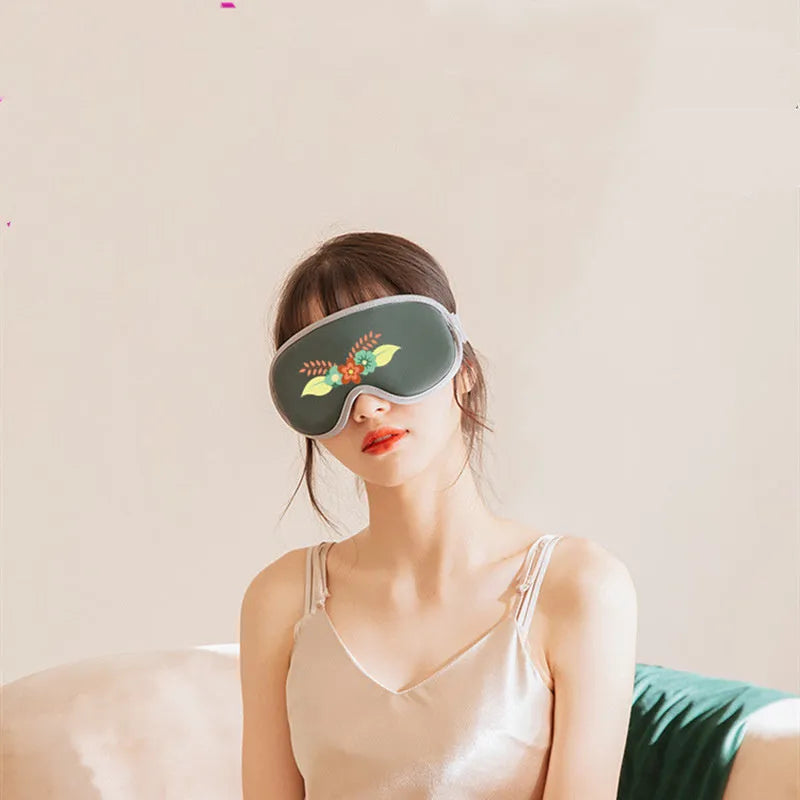 Green portable eye SPA massage goggles with USB cable on a white background.