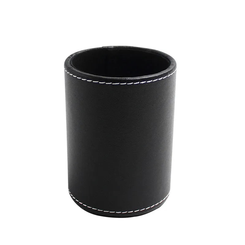 Round black leather pen holder on desk with pens