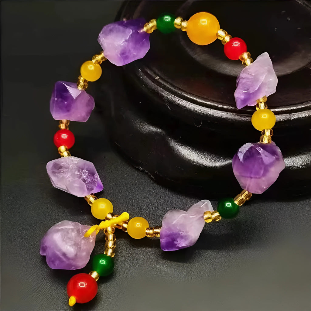 Natural shaped purple amethyst bead bracelet with a silver fu charm on an adjustable knotted cord.