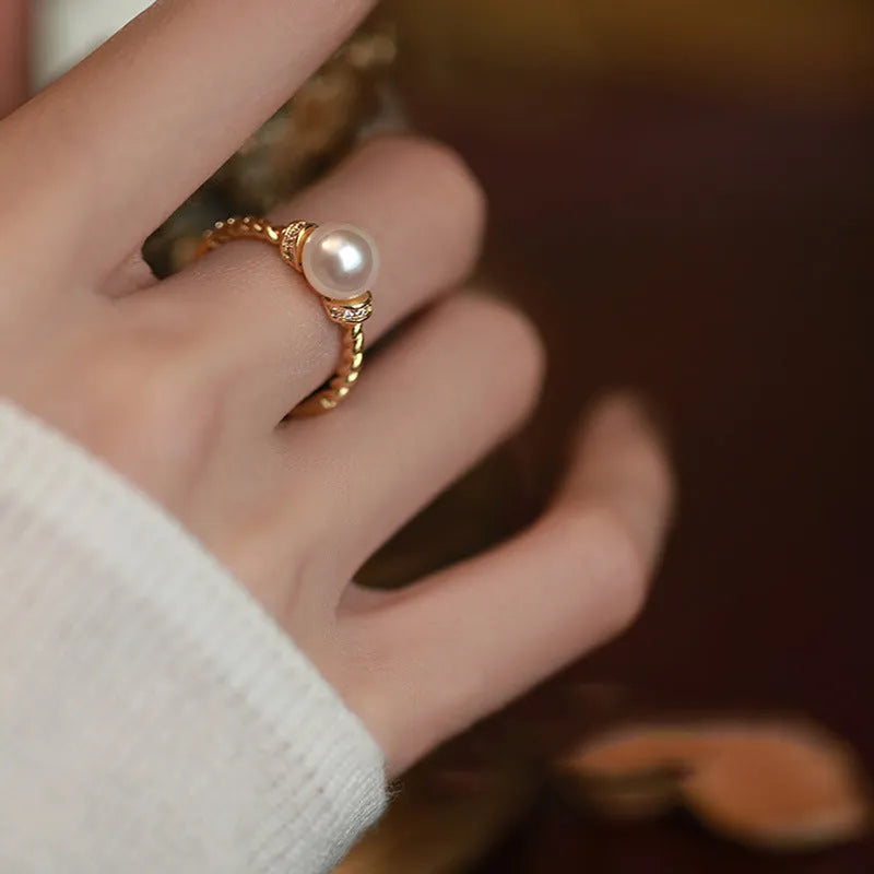 Adjustable copper ring with geometric twist design and pearl inlay in gold colour