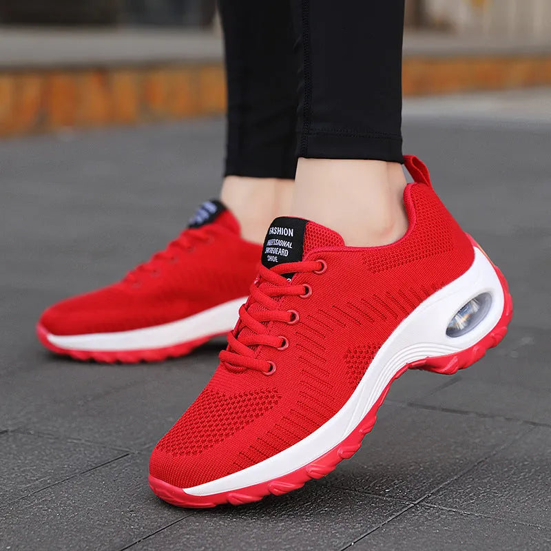 Red women's mesh sneakers with round toe and front lace-up design showing low top silhouette