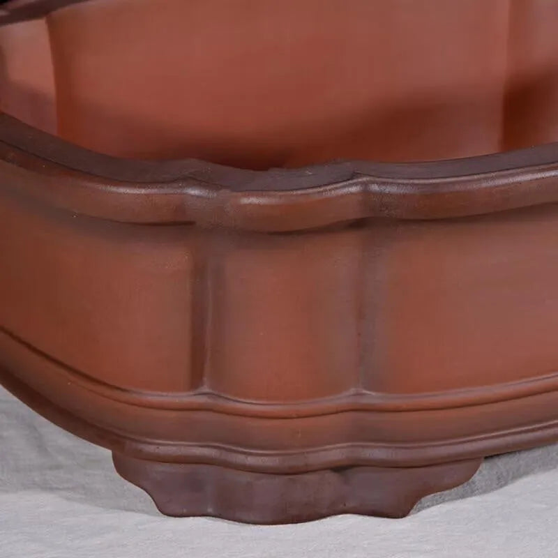 Antique-style purple clay flowerpot with Chinese decorative motifs showing tree stump, pine, cypress, pomegranate, golden marble, antique jade belt, and crabapple designs