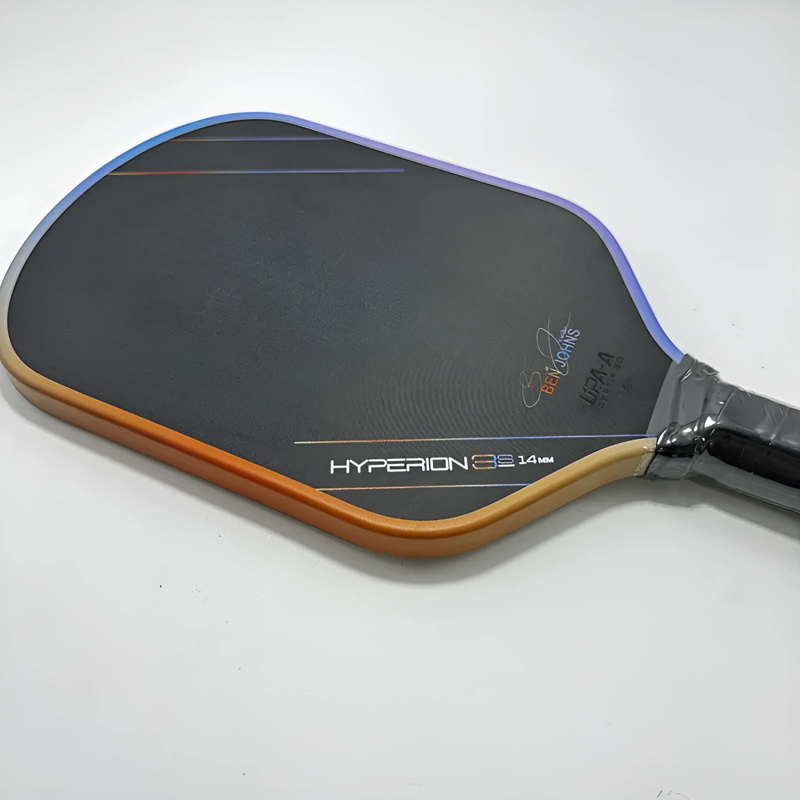 Multicolour matte-finish pickleball racket showing carbon fibre texture and honeycomb core construction.
