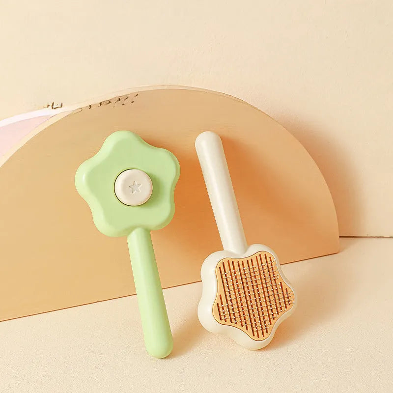 Green handled self-cleaning pet comb with stainless steel teeth on a white background.