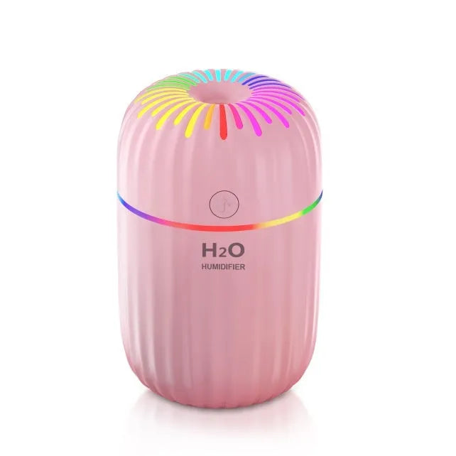 Small white cube-shaped USB humidifier with water tank on a wooden desk.