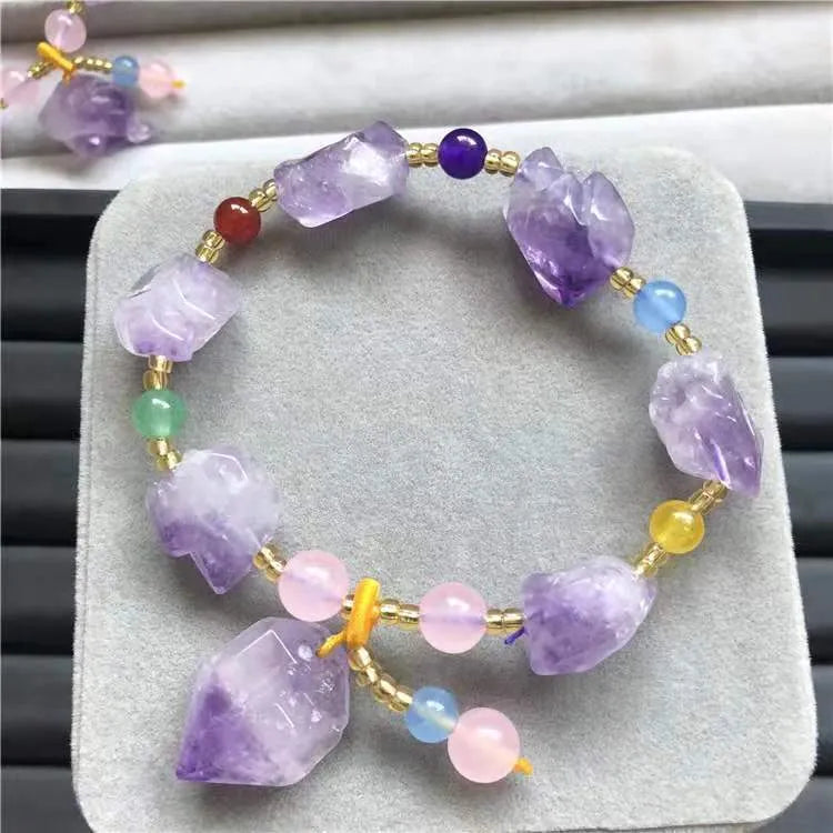 Natural shaped purple amethyst bead bracelet with a silver fu charm on an adjustable knotted cord.