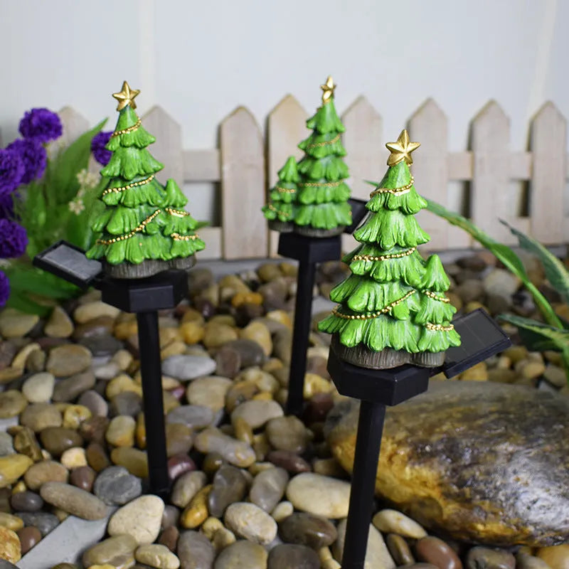 Solar Christmas tree ground plug light with resin body, warm white LED, and 40x40mm solar panel on a lawn