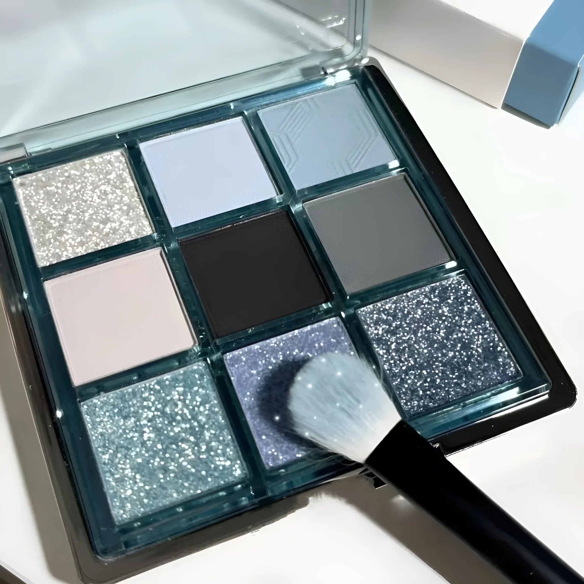 MUGELEEN nine-colour eye shadow palette showing earth tones with blue smoked variations