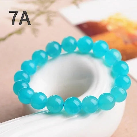 Polished Amazonite scattered beads in ice colour with size options for jewellery making next to crystal bracelet