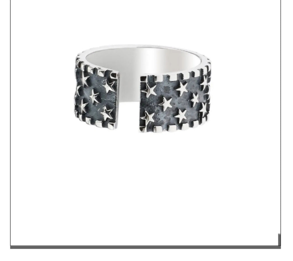 Adjustable sterling silver ring with a raised five-pointed star design on the band.