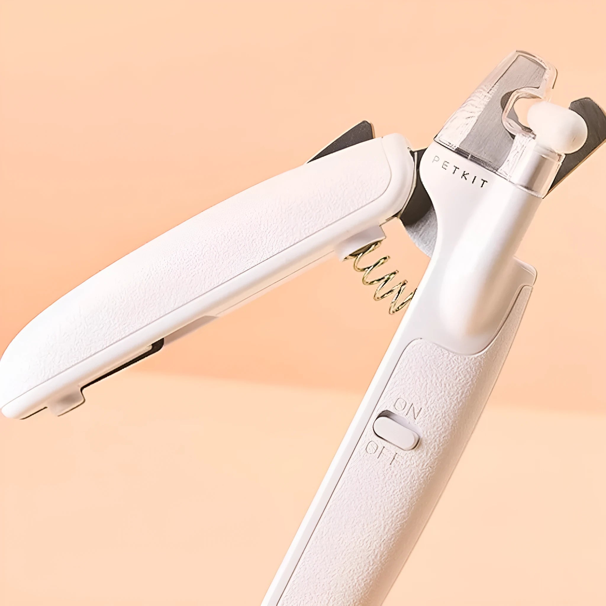 White pet nail clippers with LED light, transparent guard, and a separate nail file on a plain background.