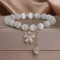 Women's white cat's eye crystal bracelet with floral tassel design and safety buckle pendant
