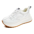 Beige women's low-top leather casual shoes with cross strap and a distinctive English muffin heel.