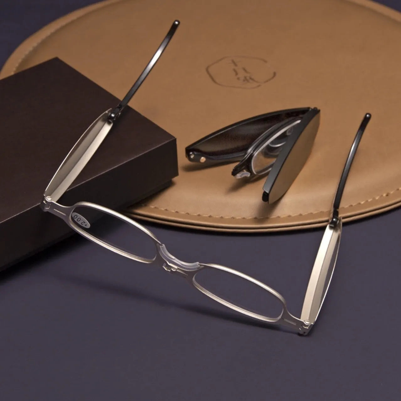 Black retro folding reading glasses with a ring detail, shown in open and closed positions.