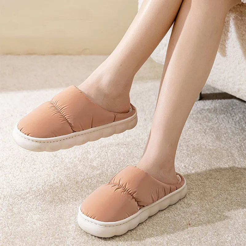 Blue winter house slippers with artificial leather upper, thick rubber sole, and plush lining on a wooden floor.