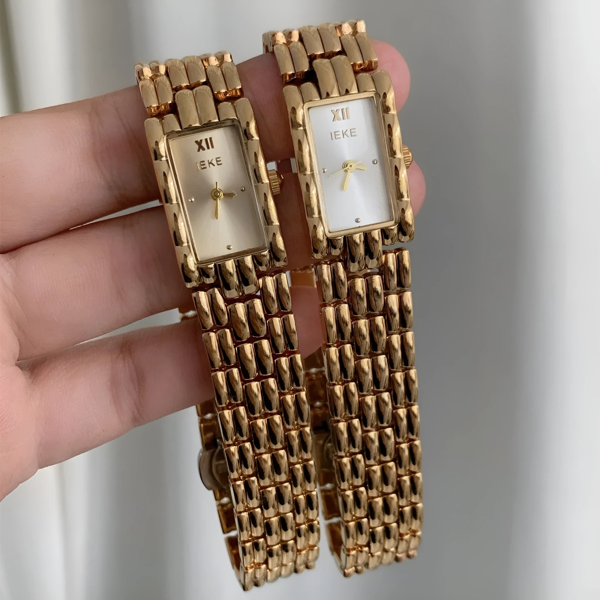 Women's silver and gold bracelet-style watch with 15mm dial and butterfly clasp