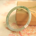 Green waxy jade geometric bracelet on a flat surface, 10mm bead thickness, handcrafted Chinese style