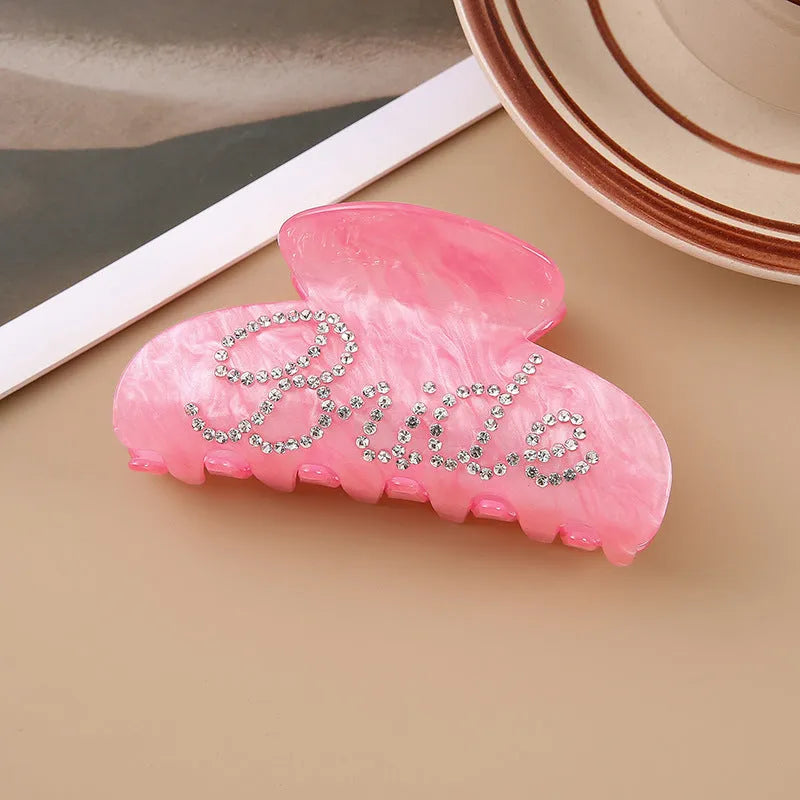 Acrylic hair barrette with diamond pattern and English letters measuring 10cm wide in pink colour