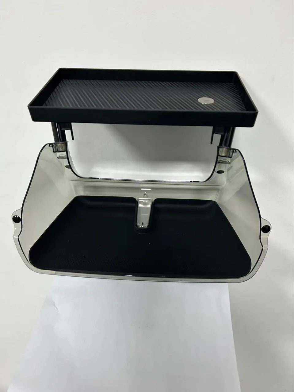 White ABS plastic storage box fitted under the screen of a Tesla Model 3 for small items