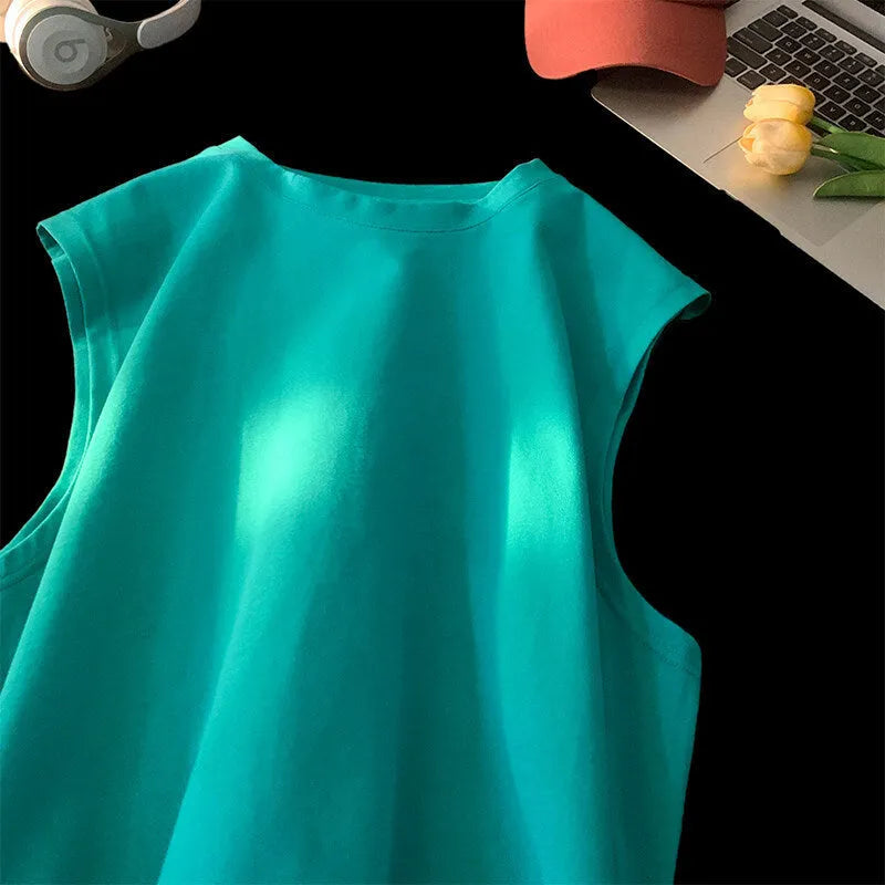A man's loose grey cotton sleeveless t-shirt on a hanger, showing the straight hem and pullover design.