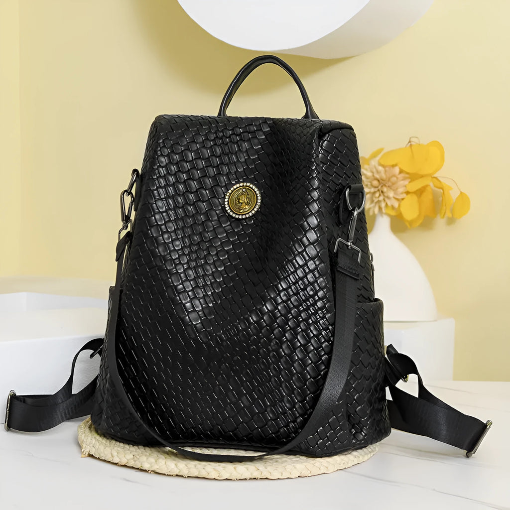 Women's large capacity anti-theft backpack in black PU material with contrast stitching and woven accents for travel