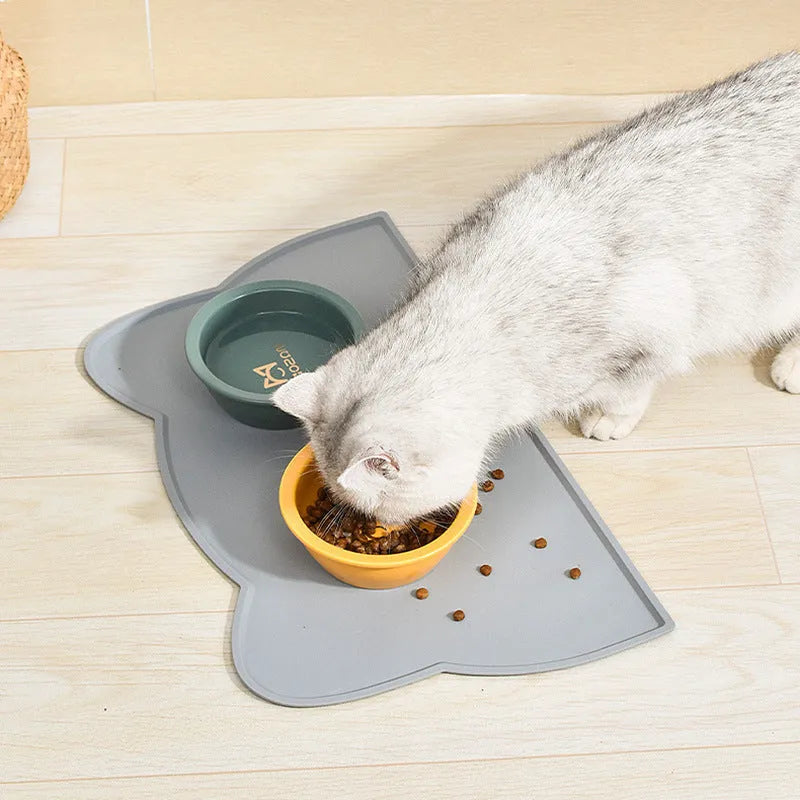 Waterproof silicone pet feeding mat in grey, cat head shape, 44x24cm, with a pet bowl on top