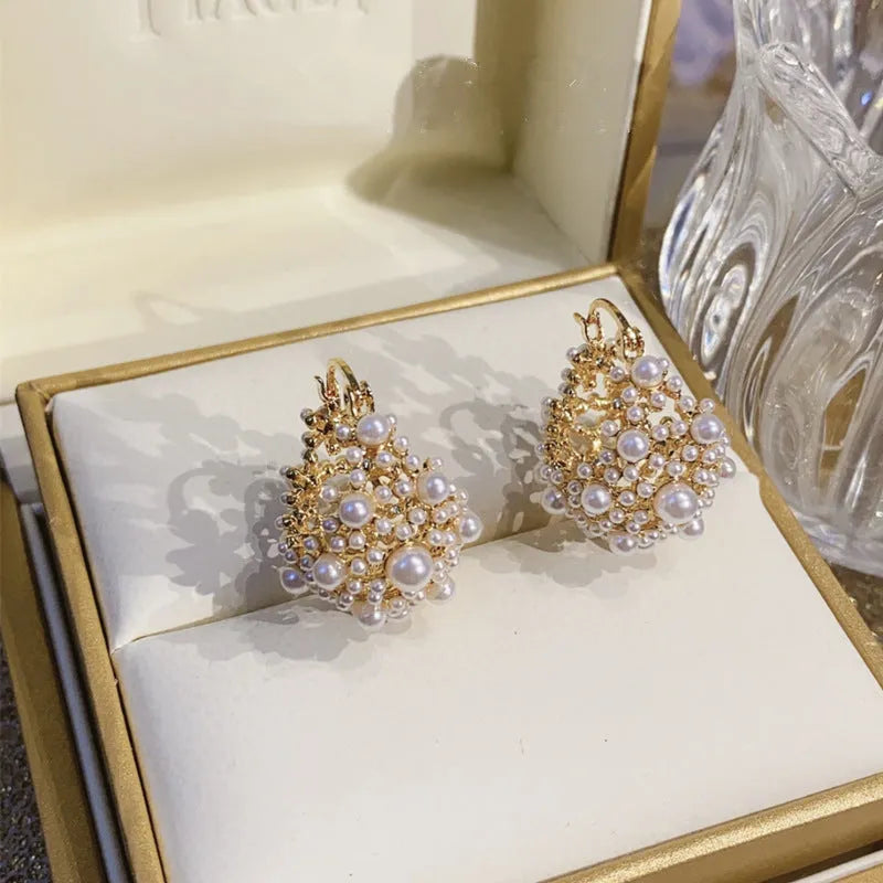 Gold tone copper flower basket shaped earrings with small rice-shaped pearl inlay beads.