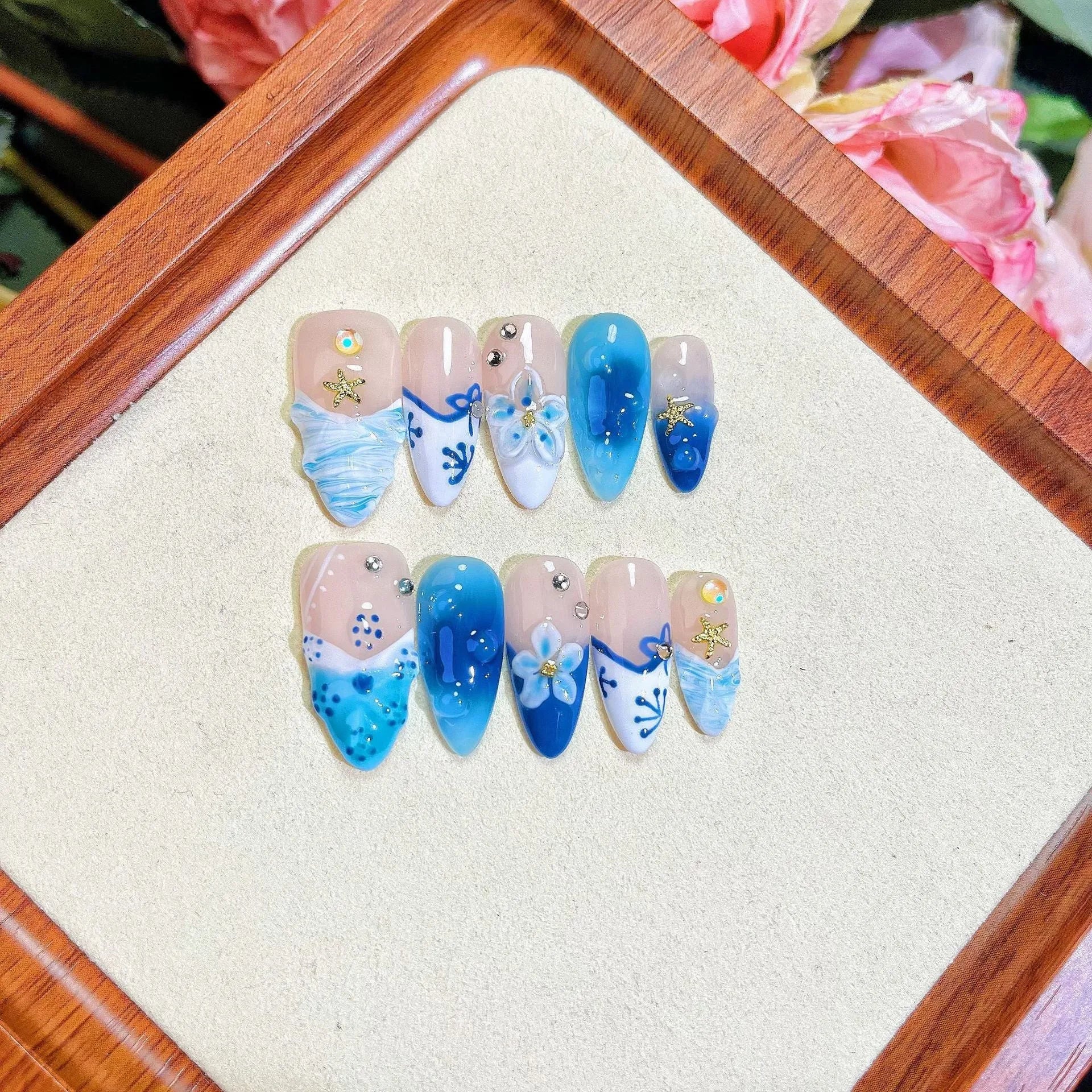 Blue hand-painted carved false nails in summer ice colour with transparent finish