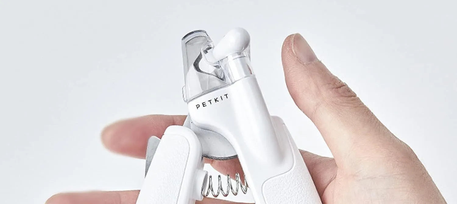 White pet nail clippers with LED light, transparent guard, and a separate nail file on a plain background.