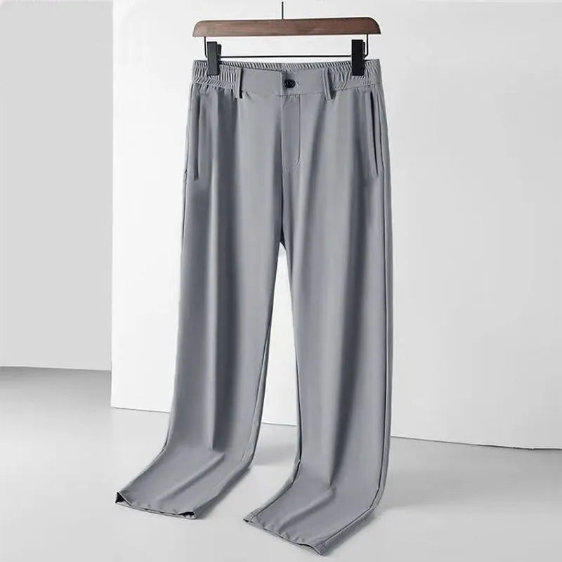 Men's black ice silk loose-fit straight leg trousers with elastic waistband laid flat.