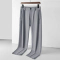 Men's black ice silk loose-fit straight leg trousers with elastic waistband laid flat.