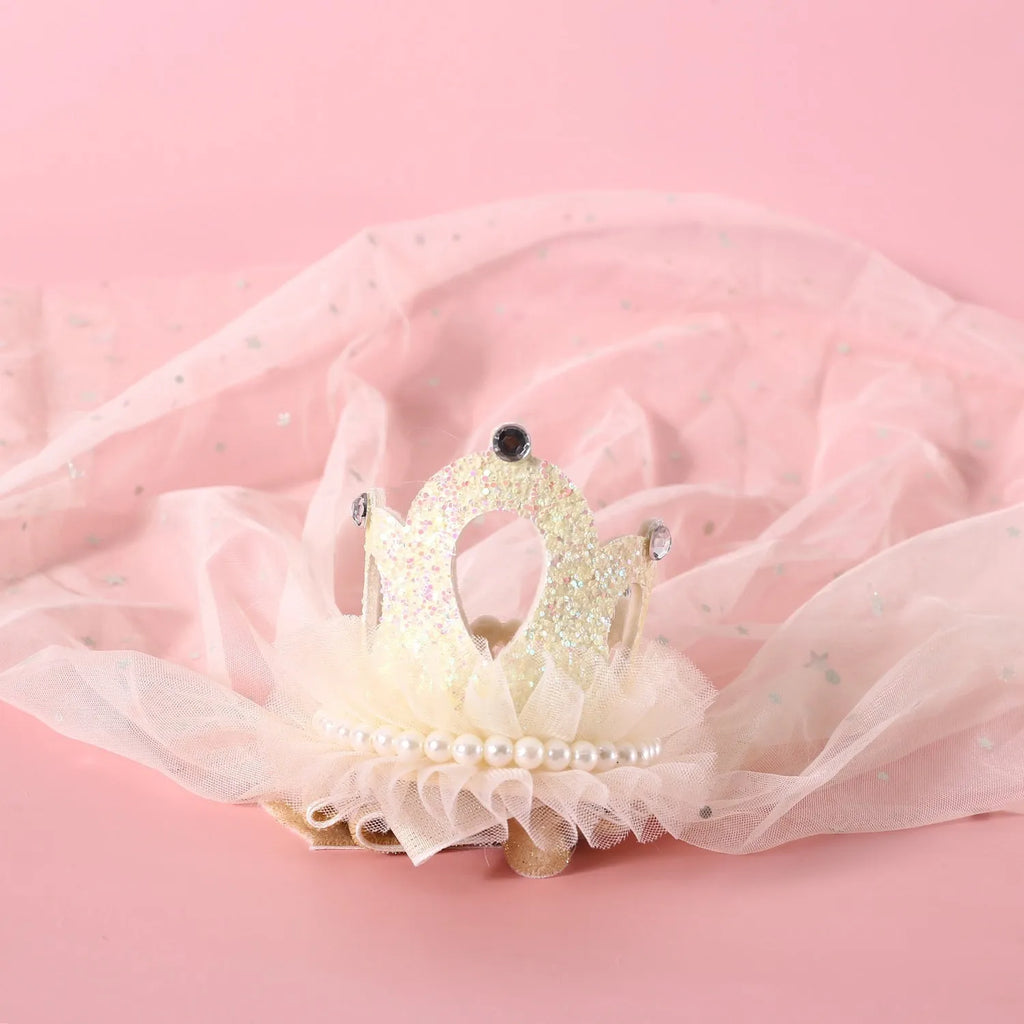 A beige and a pink princess crown headdress for cats on a white background.