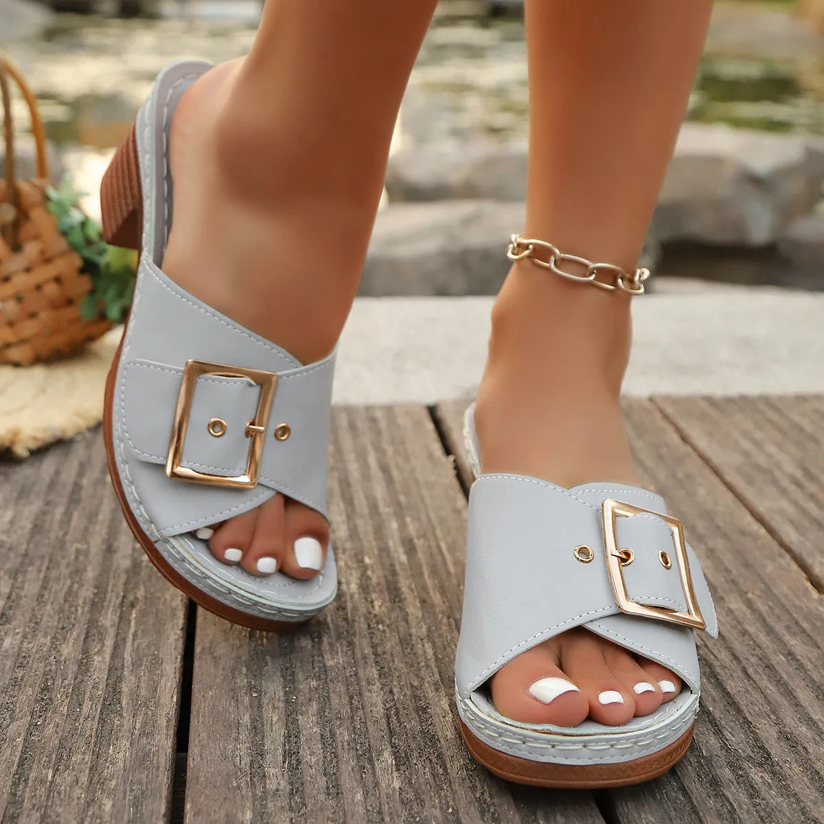 Women's black chunky heel slippers with a silver metal buckle fastening on the strap