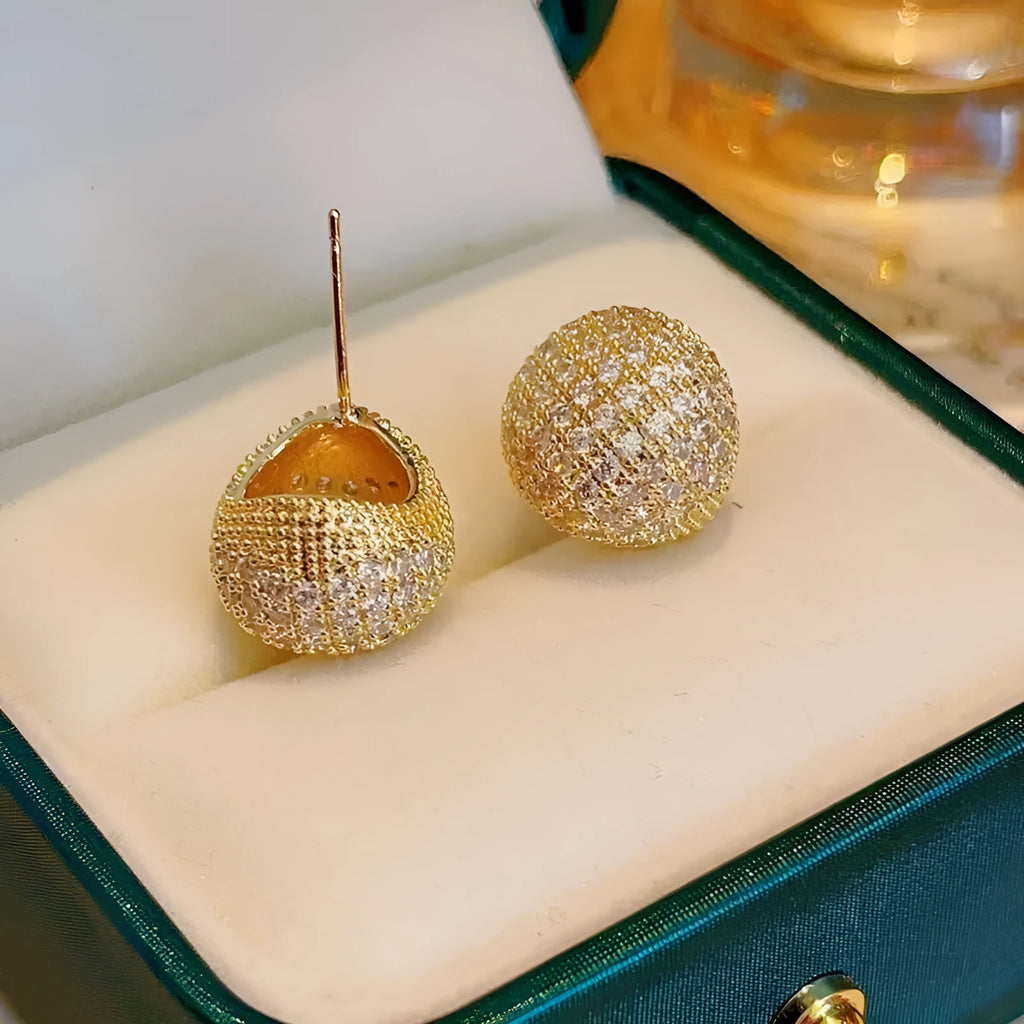 Gold and white drop-shaped geometric earrings with sphere elements and sparkling crystals