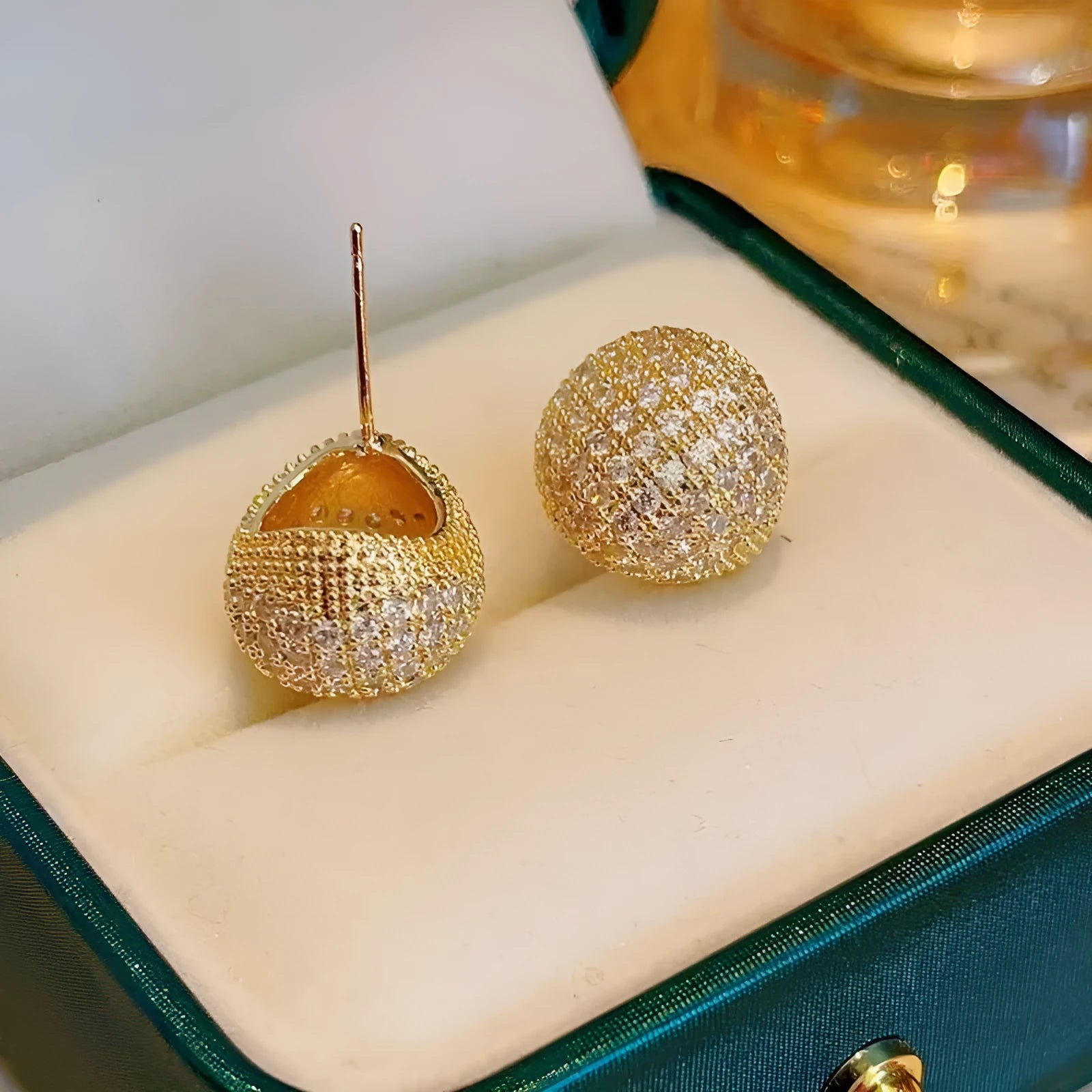 Gold and white drop-shaped geometric earrings with sphere elements and sparkling crystals