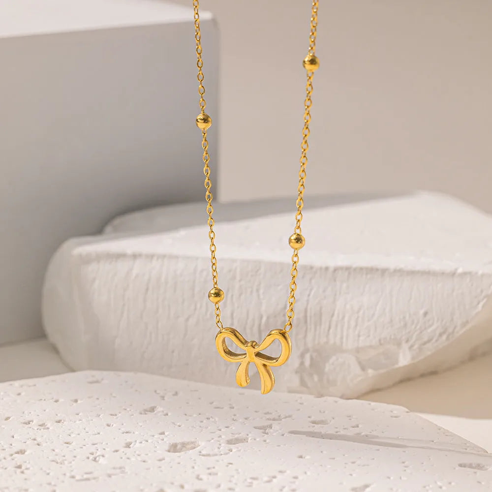 Gold electroplated bow pendant necklace on adjustable titanium steel chain