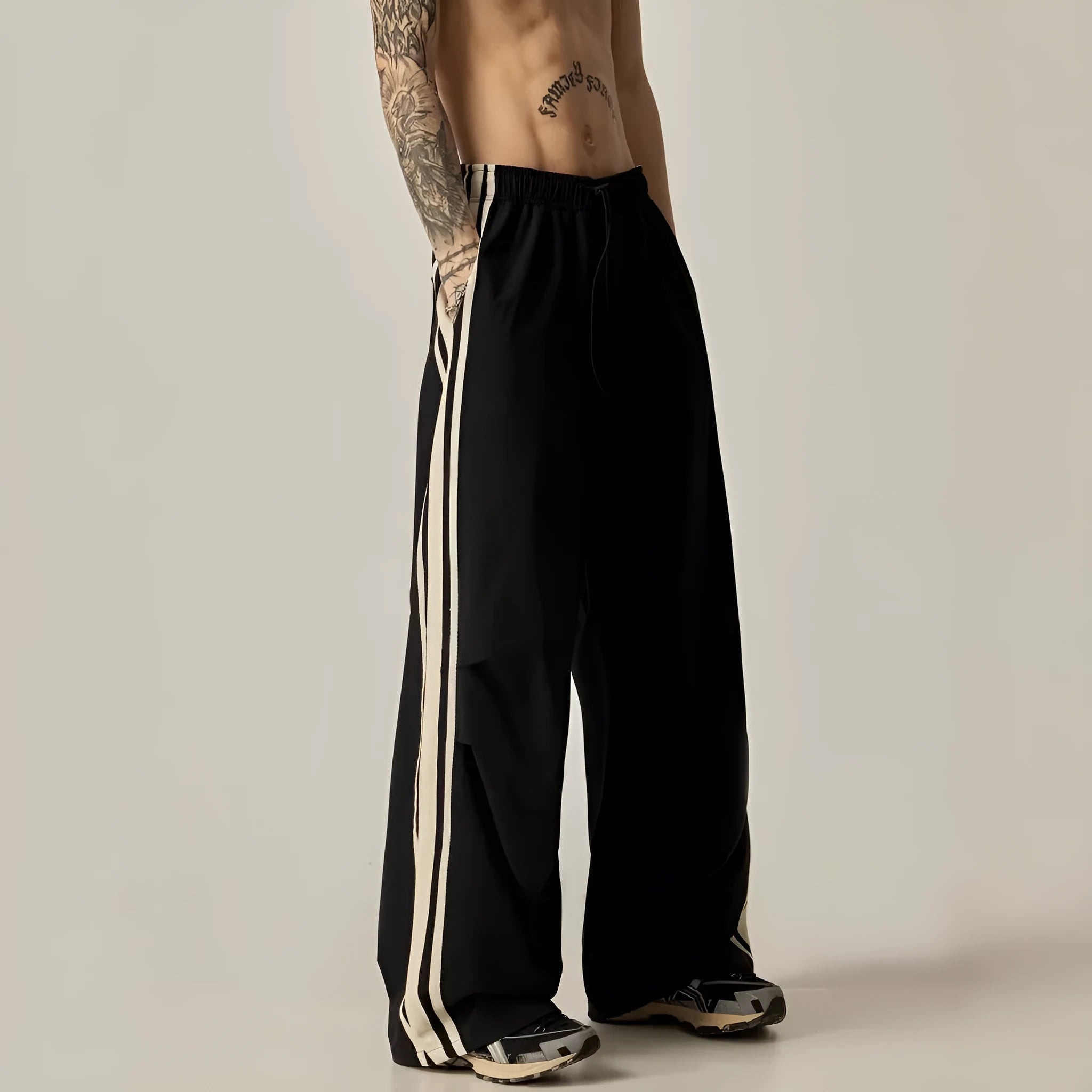 Black wide leg climbing trousers for men showing high waist and straight leg design on hanger.