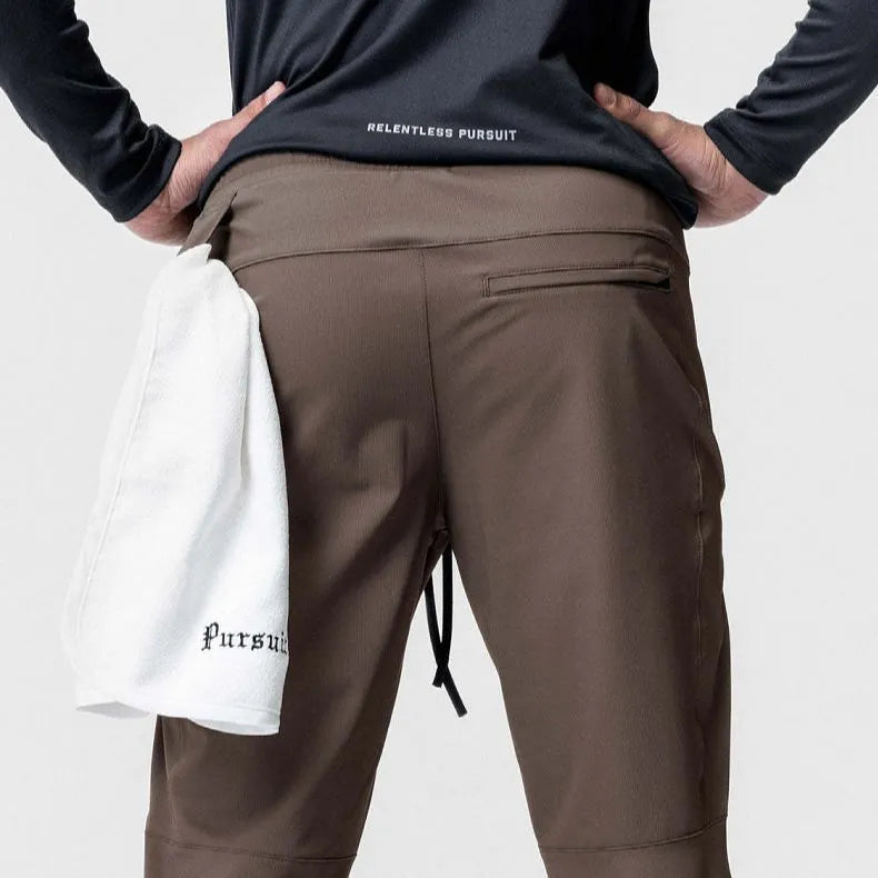 Men's grey quick-dry fitness pants with ankle ties shown in loose fit for exercise