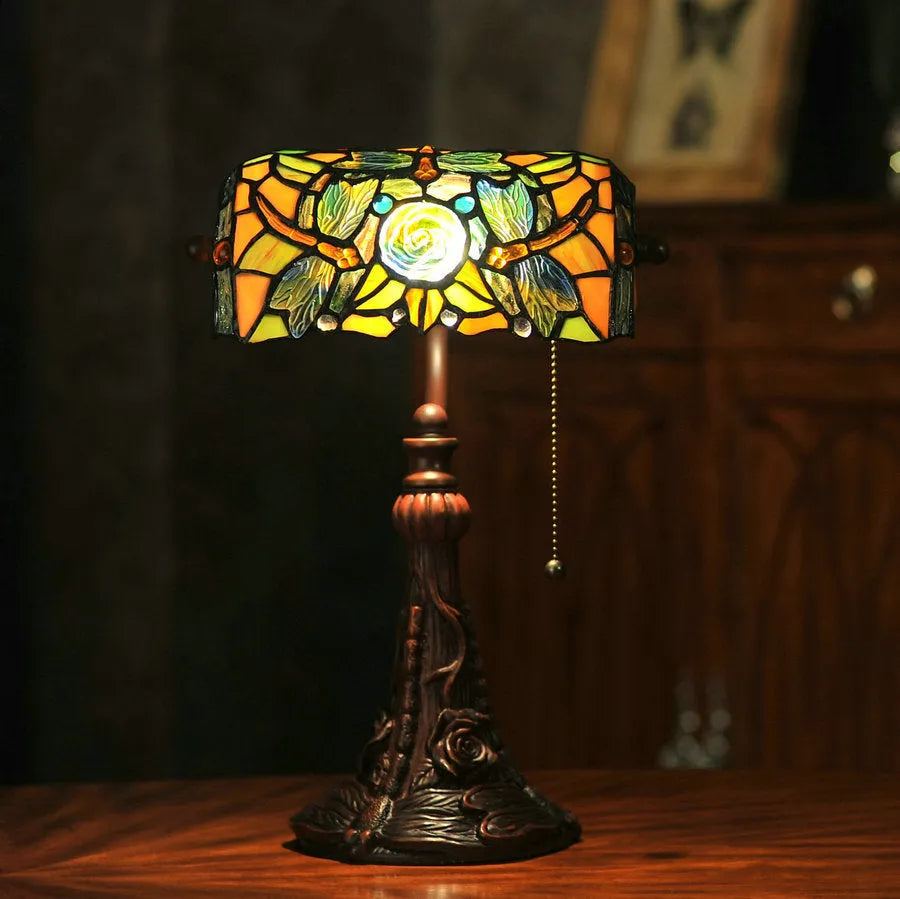10-inch Tiffany table lamp with coloured glass shade and resin base on a desk.
