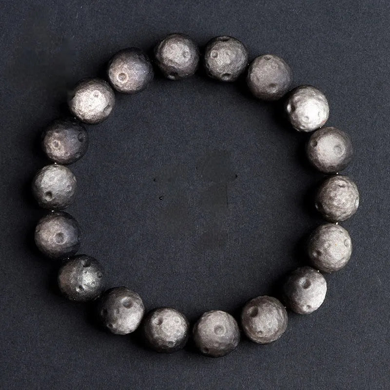 Obsidian crater ball bracelet in silver stone meteorite colour with textured round beads.