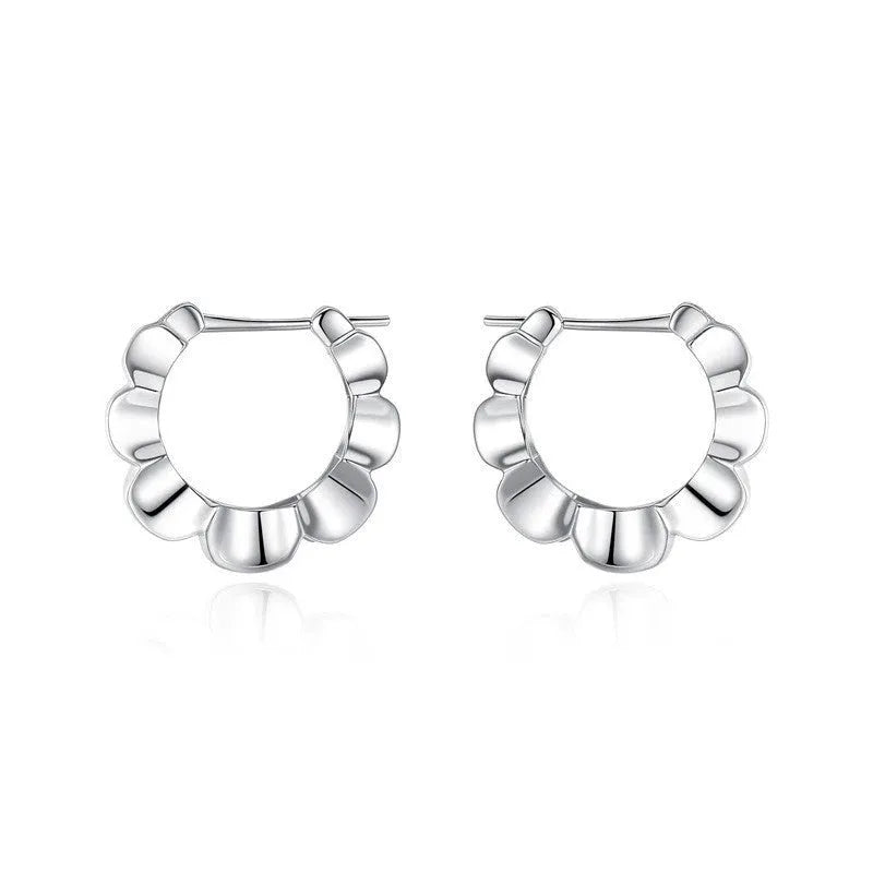 A pair of sterling silver geometric earrings with round elements on a white background.