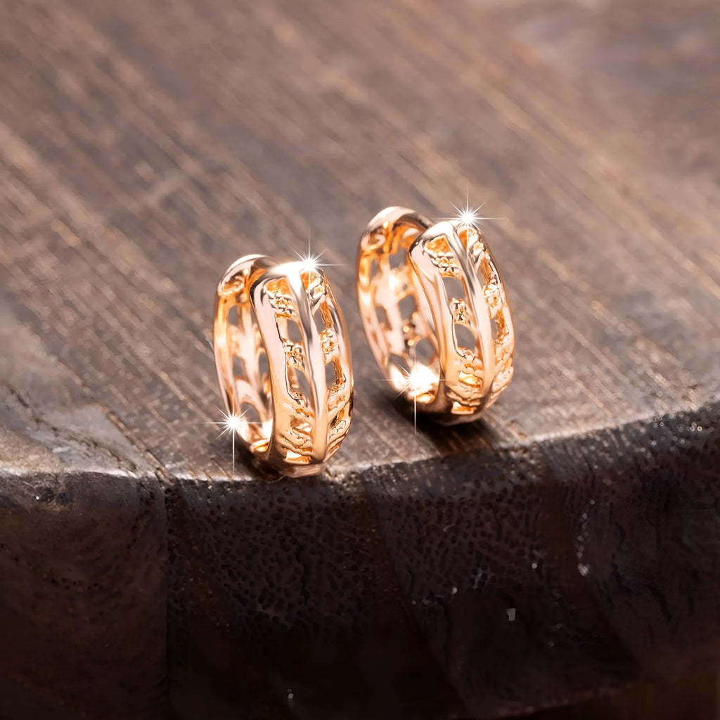 A pair of rose gold hollowed earrings with intricate leaf and heart shapes.