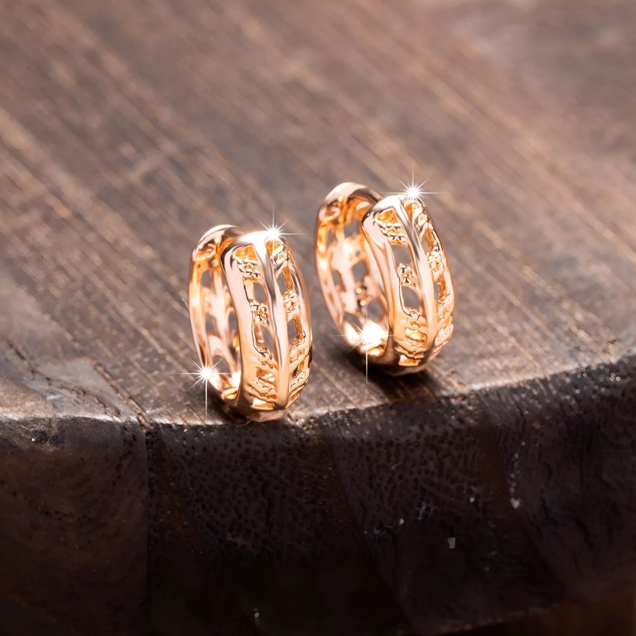 A pair of rose gold hollowed earrings with intricate leaf and heart shapes.