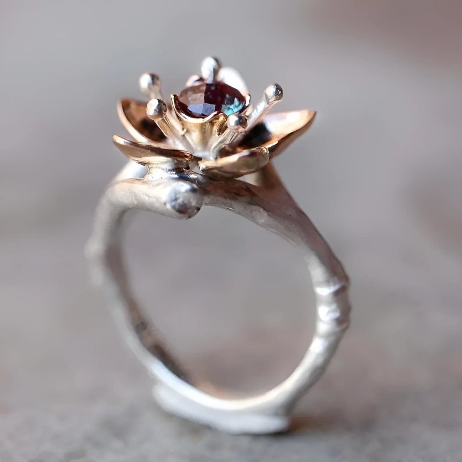 Silver two-tone women's ring with a geometric floral design on a finger.